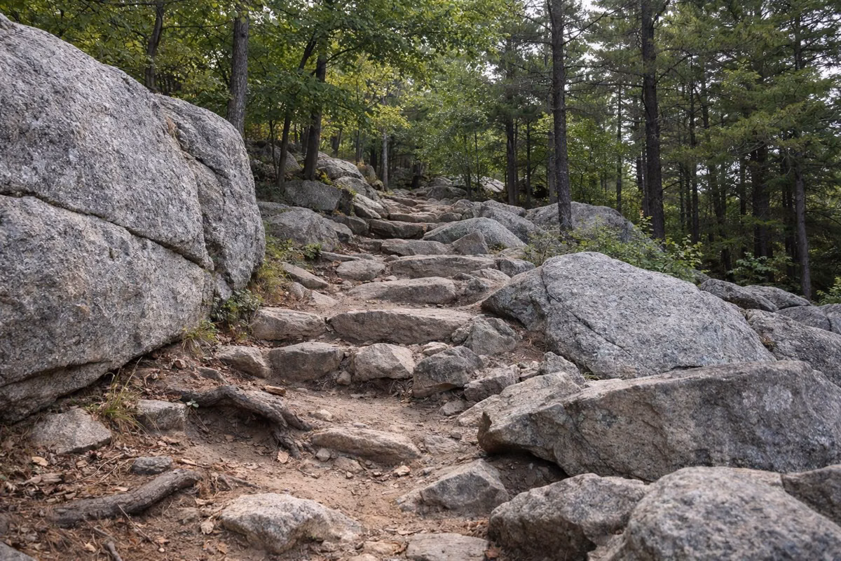 Rocky hiking trail climbing between granite ledges and oaks